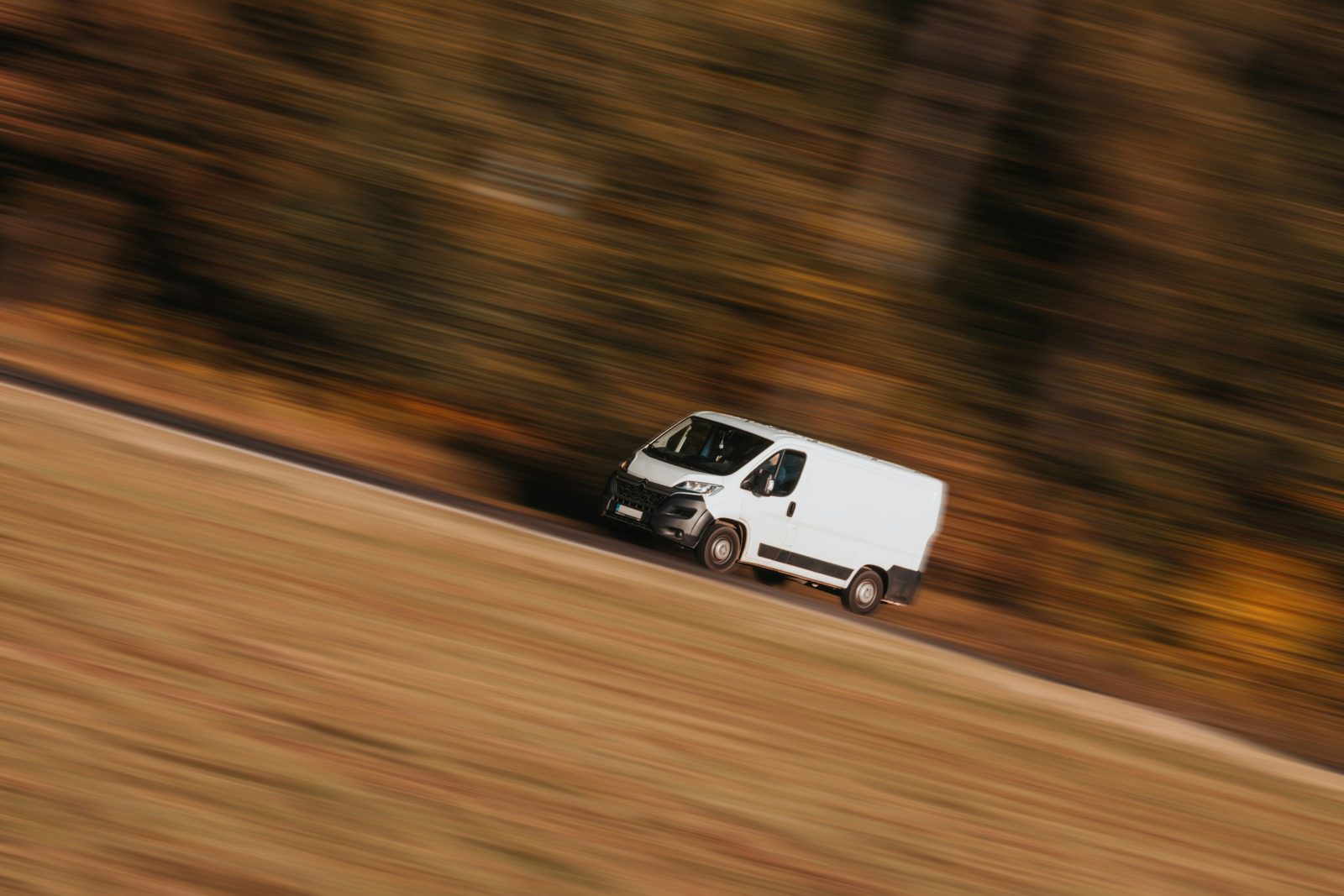 White collection van driving along a country road