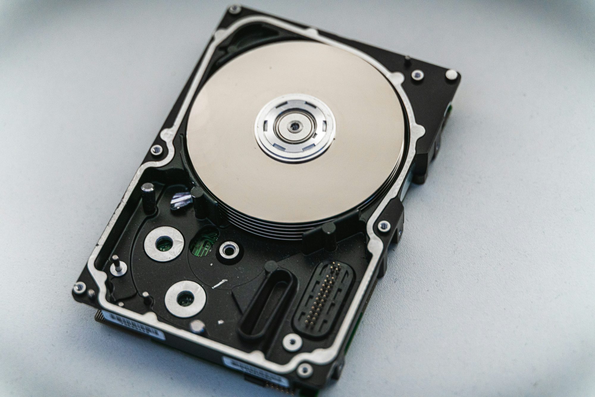 Opened hard drive showing its platter and read head
